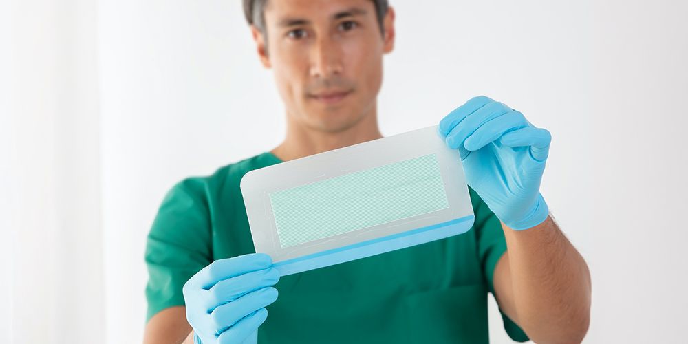 Healthcare professional holding up a Leukomed Sorbact wound dressing Healthcare professional holding up a Leukomed Sorbact wound dressing